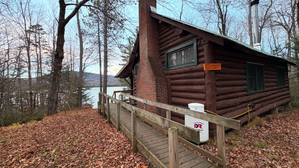 Dartmouth Cabins logo, image of cabin with smoke rising from chimney.