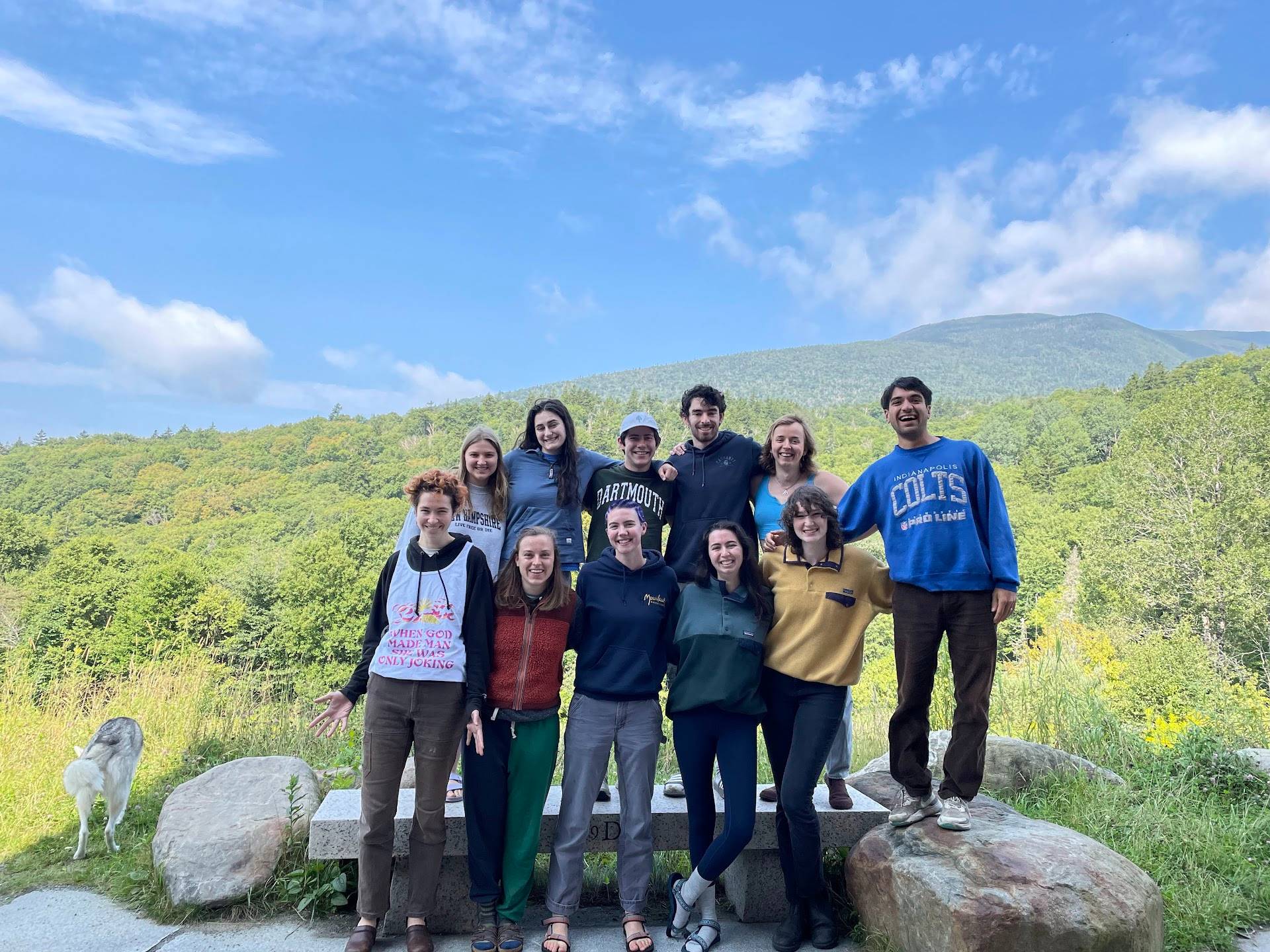 The 10 members of summer crew stand together with Mt. Moosilauke in the sunny background. 